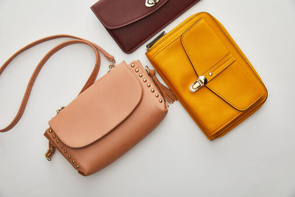 вид сверху на стильные сумки, изолированные на сером
 