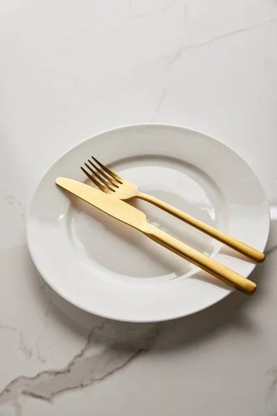 Plato Blanco Limpio Con Cuchillo Dorado Brillante Tenedor Mesa Mármol — Foto de Stock