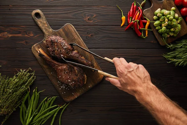 Cropped View Man Taking Tasty Meat Cutting Board Tweezers — Stock Photo, Image