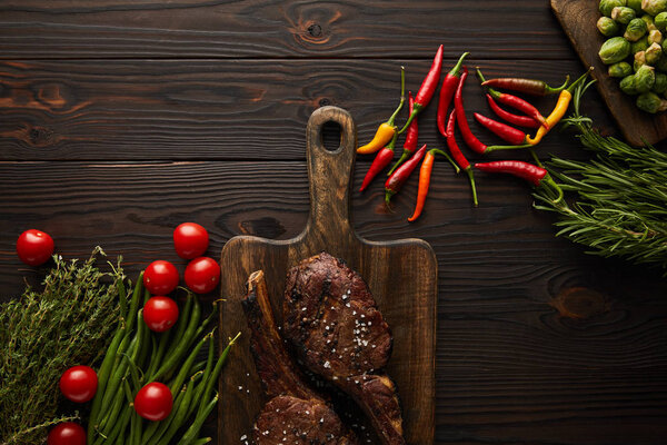 top view of meat, chili peppers, cherry tomatoes, green peas, greenery, brussels sprouts 
