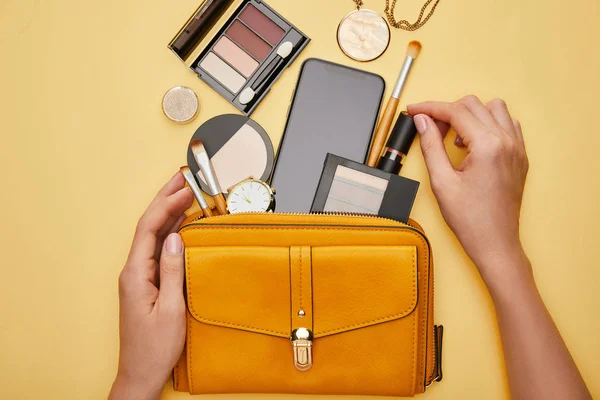 Cropped view of woman holding lipstick near bag isolated on yellow — Stock Image Cropped View Woman Holding Lipstick Bag Isolated Yellow Stock Image