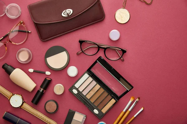 Top view of brown bag near glasses and lipsticks on crimson — Stock Image Top View Brown Bag Glasses Lipsticks Crimson Royalty Free Stock Images