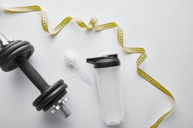 top view of measuring tape near dumbbell and sports bottle on white  clipart
