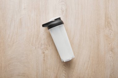 Tahta yüzeyinde protein içeceği olan spor şişesinin üst görüntüsü 