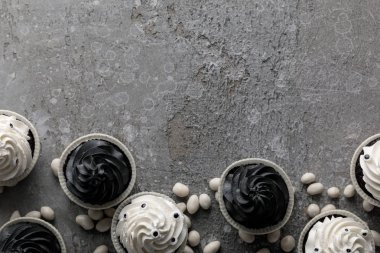 Lezzetli Cadılar Bayramı çörekleri ve beton gri yüzeyde beyaz tatlılar.