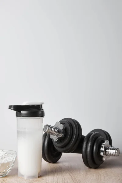 Sportflasche Mit Proteinshake Der Nähe Von Kurzhanteln Isoliert Auf Grau — Stockfoto