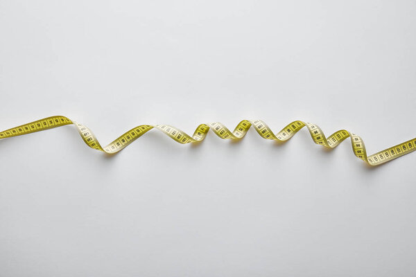 top view of yellow measuring tape on white 