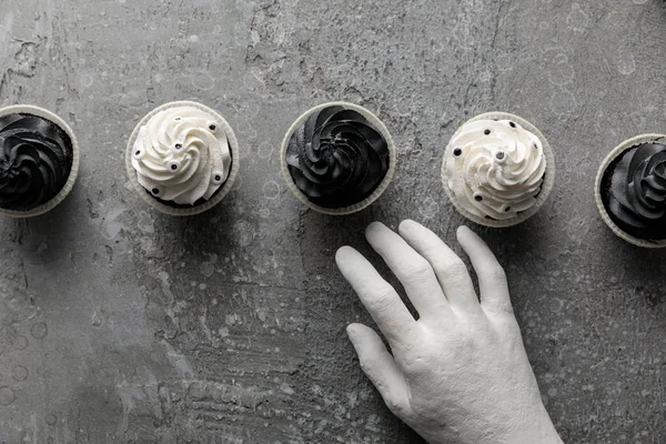 Πάνω Όψη Του Διακοσμητικού Χεριού Κοντά Νόστιμα Αποκριάτικα Cupcakes Μπετόν — Φωτογραφία Αρχείου