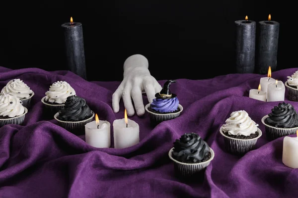 Mão Decorativa Perto Cupcakes Halloween Saborosos Velas Ardentes Pano Roxo — Fotografia de Stock