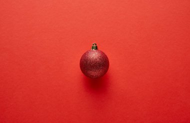 Kırmızı arka planda parlak Noel mücevherlerinin üst görünümü