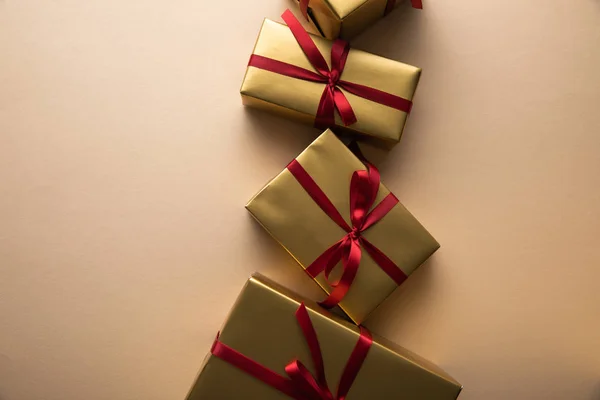 Bovenaanzicht Van Gouden Geschenkdozen Met Rode Linten Strikken Beige Ondergrond — Stockfoto