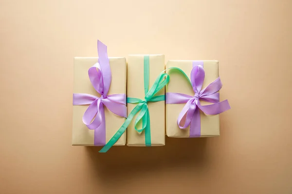 Bovenaanzicht Van Geschenkdozen Met Violette Groene Linten Beige Achtergrond — Stockfoto