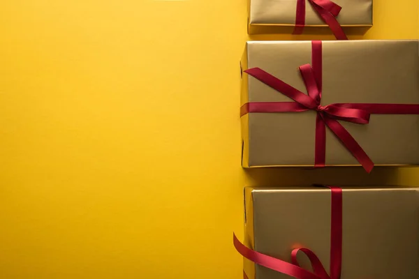 金色礼品盒顶视图 带有红色缎带 黄色背景 有复制空间 — 图库照片