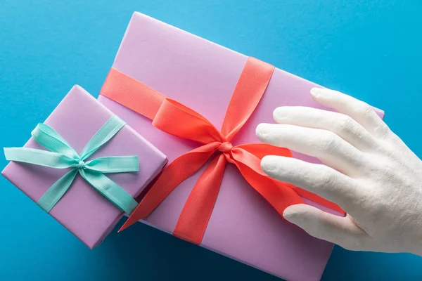 Обрізаний Вид Пофарбованої Руки Біля Фіолетових Подарункових Коробок Синьому Фоні — стокове фото