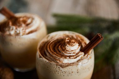 Geleneksel eggnog kokteyline yakından bakın. Krem şanti ve ahşap masada tarçın olsun.