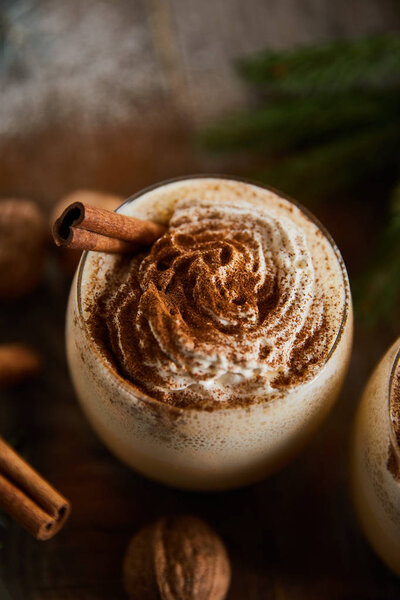 close up view of delicious eggnog cocktail with whipped cream and cinnamon 