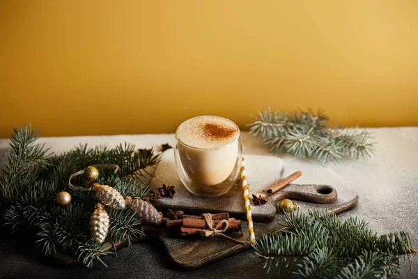 砂糖の粉 スプルースの枝 シナモンスティック ストローとオレンジの背景にクリスマスの泡で覆われたまな板上のナメクジカクテル — ストック写真