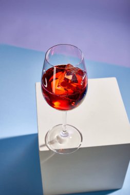 Mavi arka planda cam içinde Aperol Spritz kokteylinin yüksek açılı görüntüsü 