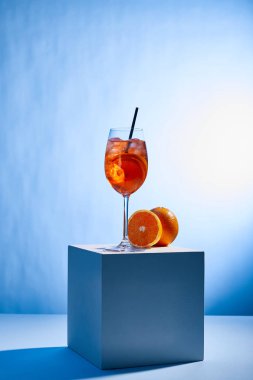 Bardakta saman ve mavi arka planda portakallı Aperol Spritz kokteyli. 
