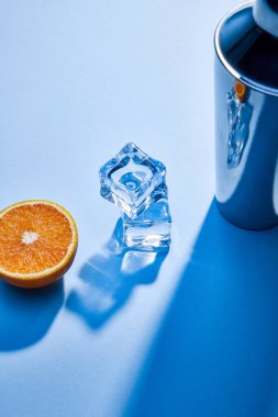 yüksek açılı turuncu, titretici, mavi arkaplanda buz küpleri 