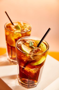 selective focus of cocktails cuba libre in glasses with straws on cube   clipart