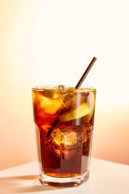 cocktail cuba libre in glass with straw on beige background  clipart