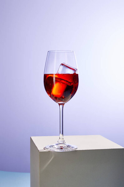 cocktail Aperol Spritz with ice cubes in glass on purple background 