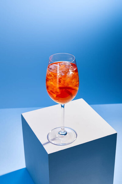 cocktail Aperol Spritz with ice cubes in glass on blue background 