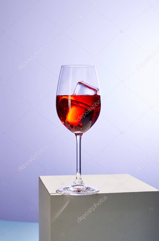 cocktail Aperol Spritz with ice cubes in glass on purple background 