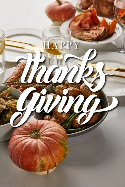 焼き野菜と全体のカボチャとお祝い感謝祭のディナーは幸せな感謝祭のイラストと白い大理石のテーブルで提供 — ストック写真