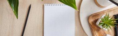 top view of green plants, blank notebook with pencil on wooden surface, panoramic shot clipart