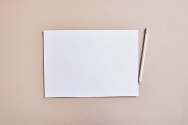 top view of blank white paper with pencil on beige surface clipart