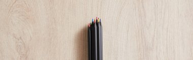 top view of black colored pencils on wooden beige surface, panoramic shot clipart