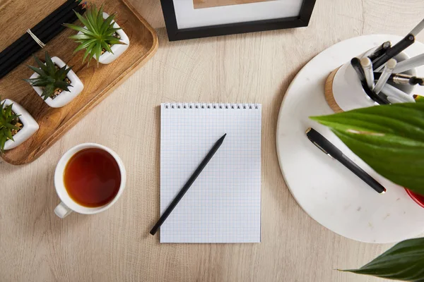 Felülnézet Zöld Növények Csésze Tea Üres Notebook Ceruzák Tollak Felületen — Stock Fotó