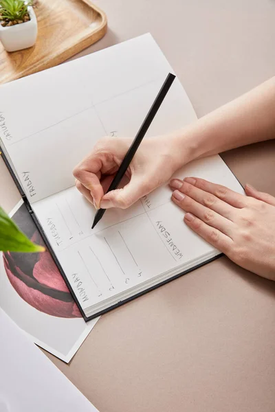 Cropped View Woman Writing Planner Beige Surface — Stock Photo, Image