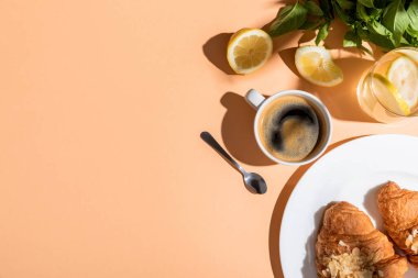 Kahvaltı için kahve ve kruvasan manzaralı bej masa üzerinde fotokopi alanı olan. 