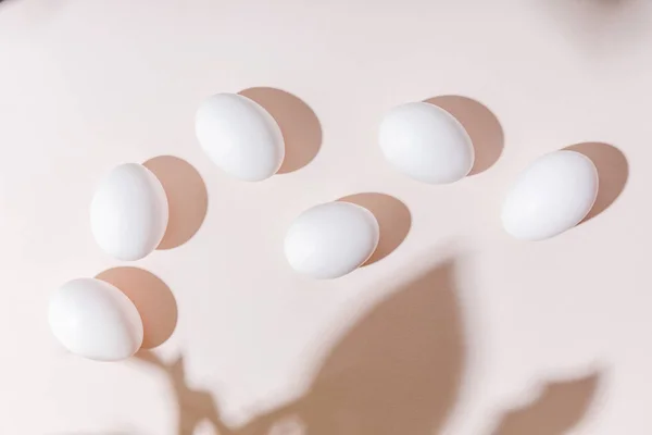 top view of white boiled chicken eggs on grey table with shadows  