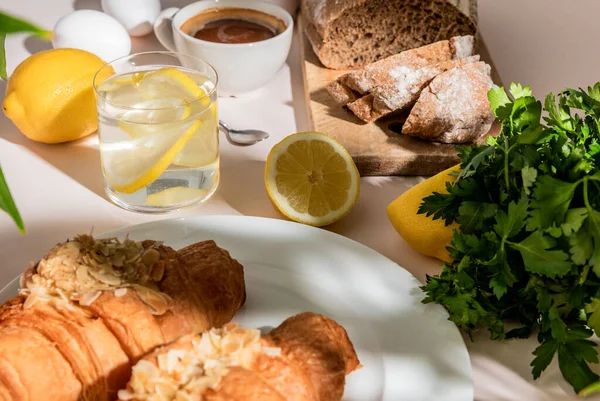 Frische Croissants Brot Petersilie Kaffee Und Zitronenwasser Zum Frühstück Auf — Stockfoto