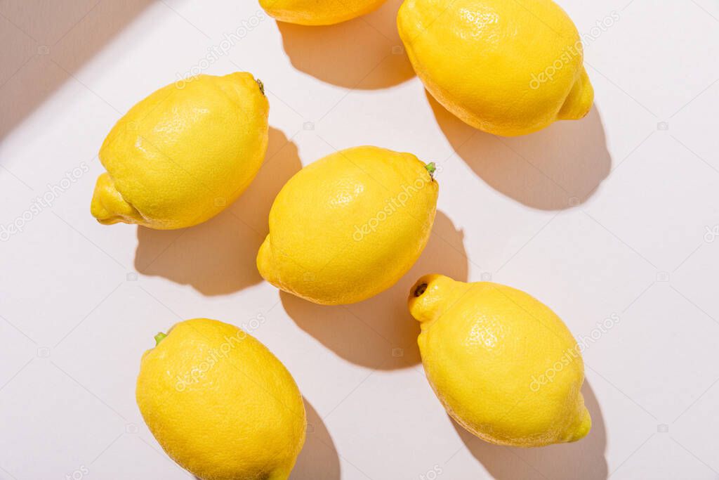 top view of whole fresh lemons on grey table with shadows