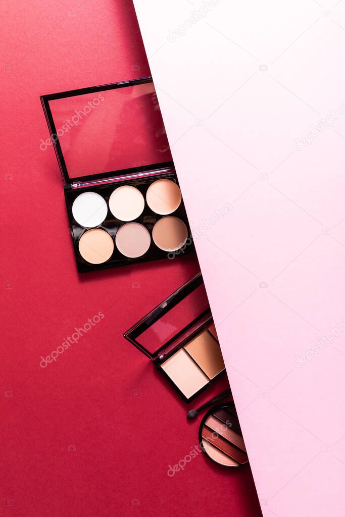 top view of pastel eye shadow and blush palettes on pink and crimson