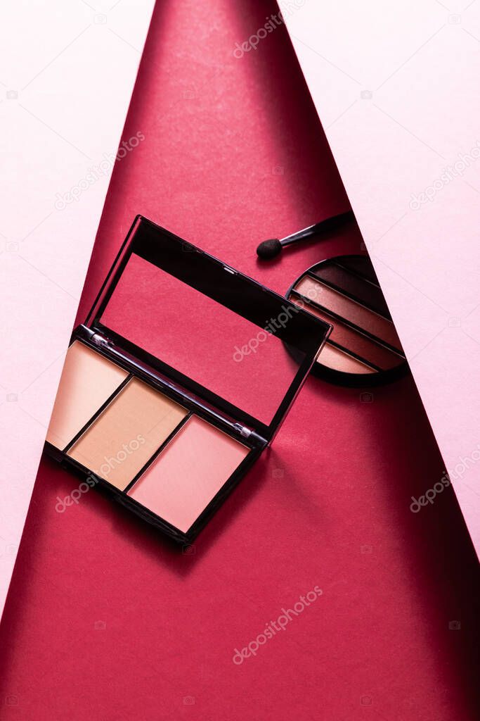  pastel eye shadow and blush palettes near eyeshadow aplacator on pink and crimson