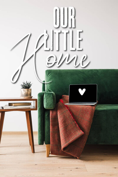 зеленый диван, одеяло и ноутбук с нарисованным сердцем возле нашего маленького дома буквы, деревянный журнальный столик с растениями и книгами
