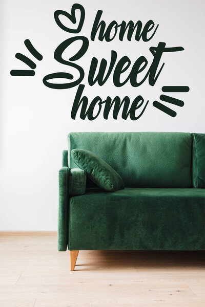 green sofa with pillow near home sweet home lettering 