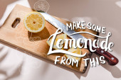 cutted lemon on wooden board on grey table with make some lemonade from this lettering