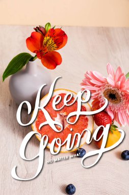 Alstroemeria, gerbera, berries, grapefruit and apricot near keep going no matter what lettering on beige clipart