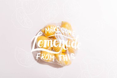 top view of yellow lemons in package on grey table with make some lemonade from this lettering clipart