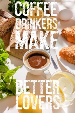 fresh croissants, bread, greenery, eggs, lemon water and cup of coffee for breakfast on grey table with coffee drinkers make better lovers lettering clipart