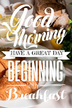 fresh croissants, bread, coffee and lemon water on grey table, selective focus with good morning, have a great day, beginning with breakfast lettering clipart