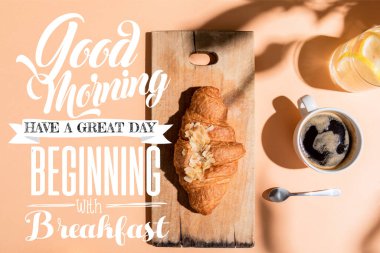 top view of coffee, water and croissant on wooden board on beige table with good morning, have a great day, beginning with breakfast lettering clipart