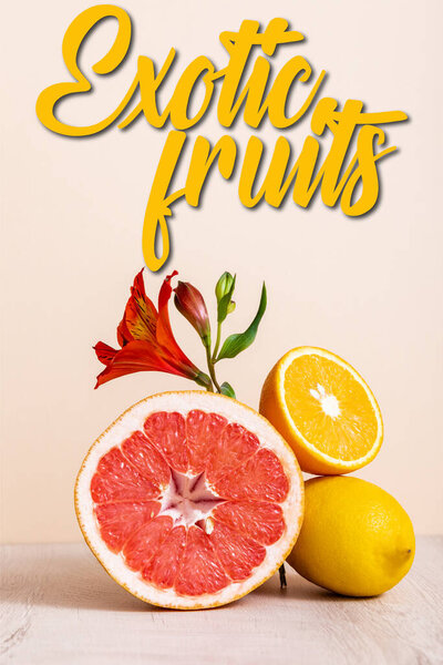 floral and fruit composition with red Alstroemeria and citrus fruits near exotic fruits lettering on beige